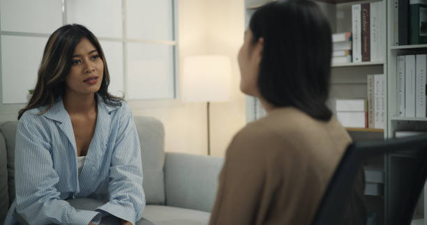 istock Psychologist supporting a young woman suffering from depression while sitting on the couch 1498092749
