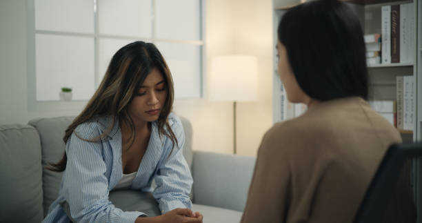 istock Psychologist supporting a young woman suffering from depression while sitting on the couch 1498092761