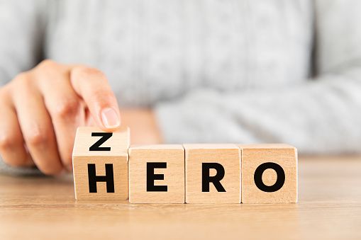 Woman hand flip wood cube change the word from zero to hero