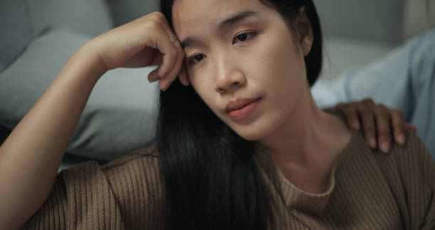 istock Psychologist supporting a young woman suffering from depression while sitting on the floor 1498092891