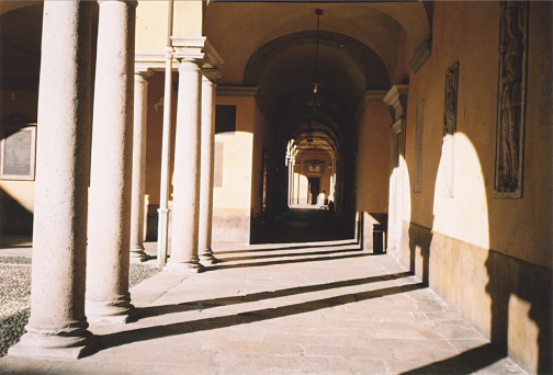 Ancient Colonnade of an Old Building Illuminated by the Sun. Architecture in Pavia, Italy. Film Photography