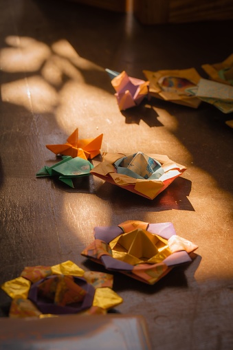 A table in a room adorned with a variety of origami pieces, creating a vibrant and colorful scene