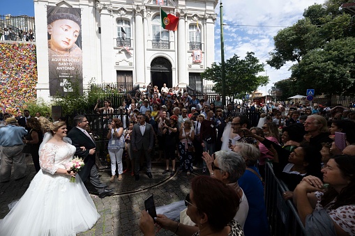 Several people are seen greeting a newlywed couple during a massive wedding in honor of St. Anthony, patron saint of the city of Lisbon. Every June 12, the city council organizes a massive wedding for dozens of couples. It is one of the most important historical and cultural events of the Portuguese capital, held on the eve of the festivities. St. Anthony is also known as the saint of marriage.