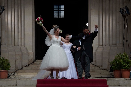 A newlywed couple performs a salute to the public in the cathedral's atrium during a massive wedding in honor of St. Anthony, patron saint of the city of Lisbon. Every June 12, the city council organizes a massive wedding for dozens of couples. It is one of the most important historical and cultural events of the Portuguese capital, held on the eve of the festivities. St. Anthony is also known as the saint of marriage.