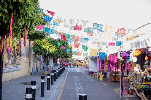 A vibrant street scene filled with many diverse market stalls showcasing a variety of colorful decorations and products