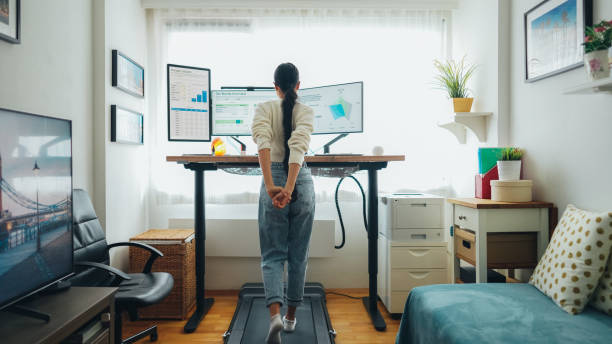 istock Woman at home office is walking on under desk treadmill 1498104079