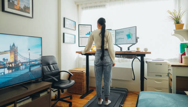 istock Woman at home office is walking on under desk treadmill 1498104155