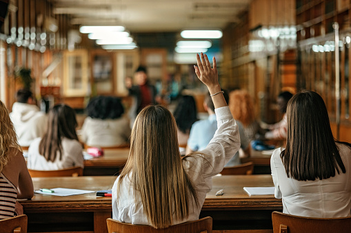 Female student raising hand to ask a question