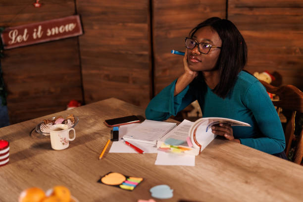 istock Diligent young woman studying at home office during Christmas holidays 1498105952
