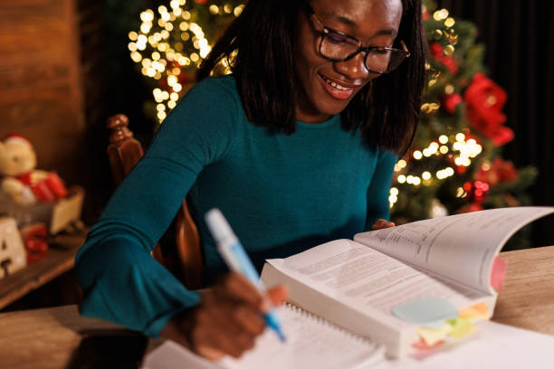 istock Young woman sitting at home office desk, highlighting notes while studying for exam 1498106013