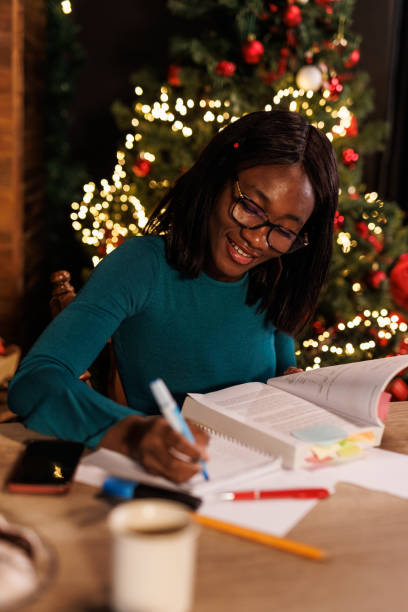 istock Young woman sitting at home office desk, highlighting notes while studying for exam 1498106092