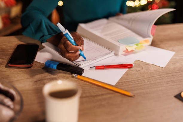 istock Young woman sitting at home office desk, highlighting notes while studying for exam 1498106298