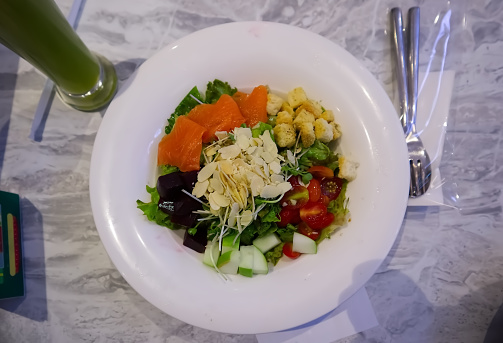 Salad on white plate on the table, healthy food background