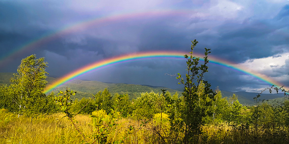 Landscape with double rainbow in the mountains
