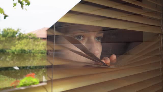 Woman with agoraphobia looking through the window