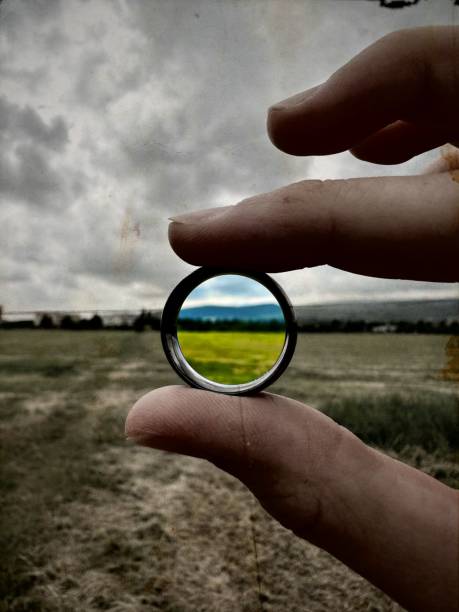 istock Selective color of a man in a grassy field holding a round frame 1498111252