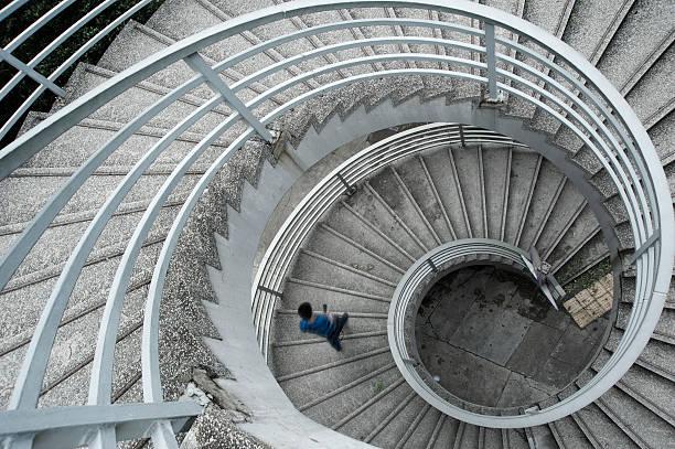 istock Man in a blue shirt walking down a spiral staircase 149811381