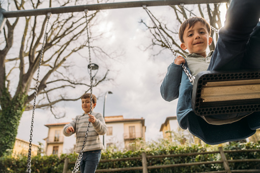Brothers swinging at the playground in Florence,Italy