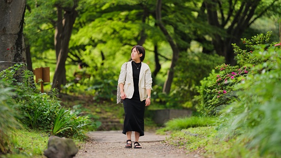 A beautiful woman is taking a walk in a public park.