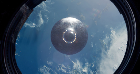 Through the spacecraft's porthole, a breathtaking scene unfolds as a UFO glides gracefully across the expanse of Earth. The window, designed to withstand the rigors of space travel, offers a mesmerizing view of the unidentified flying object soaring above our planet.