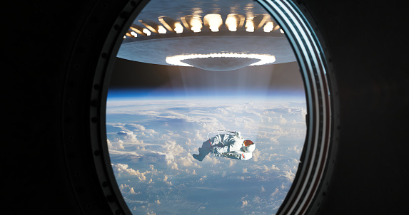 Through the spacecraft's porthole, an astonishing and alarming scene unfolds as an astronaut is being abducted by a UFO. The window, designed to offer a glimpse into the wonders of space, presents a heart-stopping view of the astronaut floating helplessly, their outstretched hand reaching towards the unidentified craft.