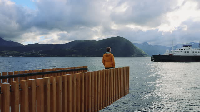Man Walking at City Pier Enjoying Fjord View in Norway