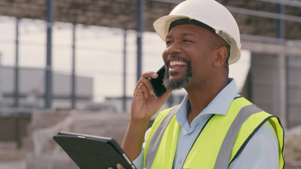 istock Man, construction and tablet with phone call at site for project management or building logistics. Male person and engineering worker talking on technology at industrial architecture design 1498116395