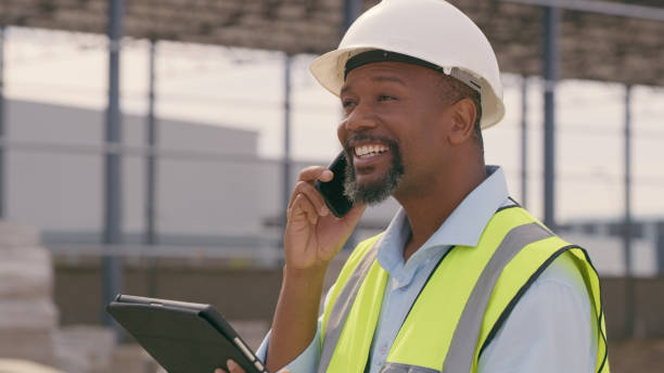 istock Man, construction and tablet with phone call at site for project management or building logistics. Male person and engineering worker talking on technology at industrial architecture design 1498116405