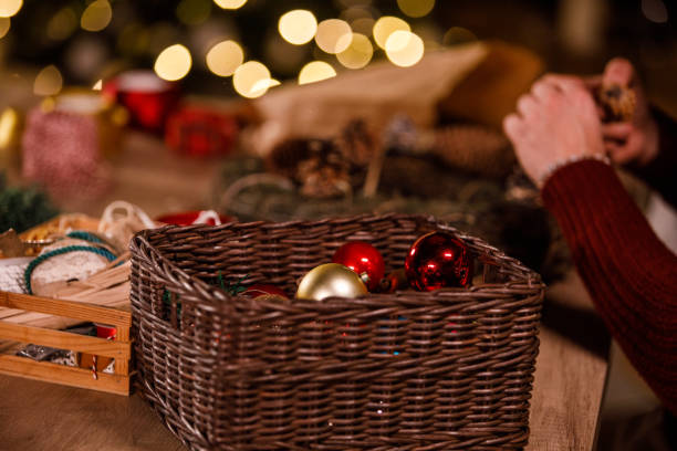 istock Creative young man decorating a Christmas wreath with pine cones and ornaments 1498116589