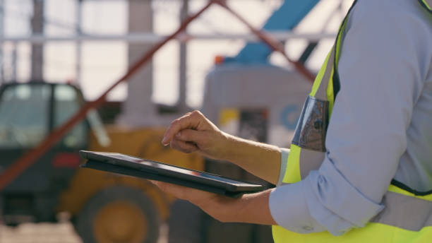 istock Hands, construction and tablet at site for project management, building logistics or app. Closeup of person and engineering worker on digital technology at industrial architecture design 1498116662
