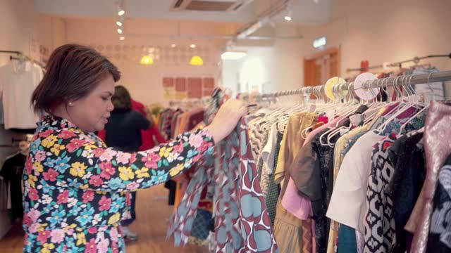 Plus Size Malaysian Woman Buying Clothes at Local Thrift Shop Wearing Floral Dress