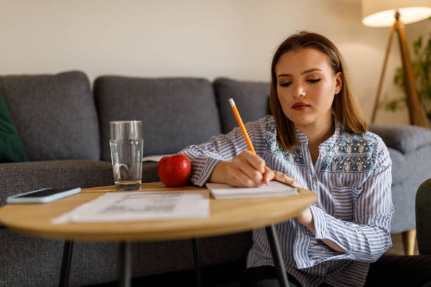 istock Young female student writing research and studying about nutrition 1498118130