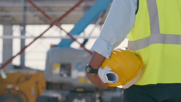 istock Hand, architect with blueprint and helmet at construction site. Project management, civil engineering and safety, hands of man engineer for building inspection, planning and maintenance 1498118542