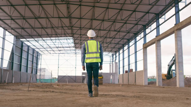 istock Construction site, man and walking outdoor for inspection on building project, architecture and development. Male engineer manager planning industry safety, infrastructure and vision 1498118544