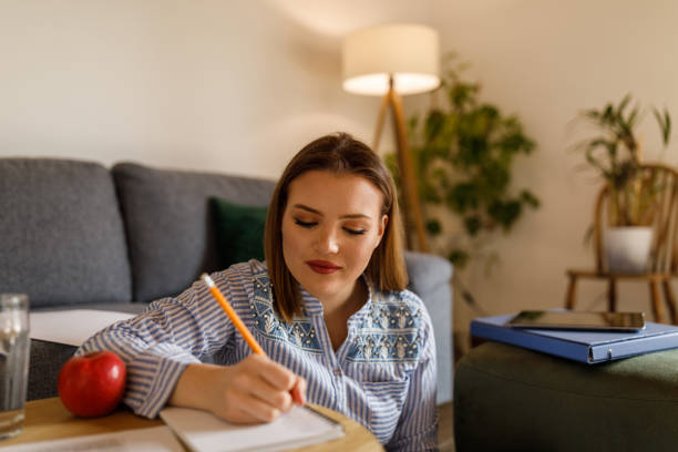 istock Young female student writing research and studying about nutrition 1498118766