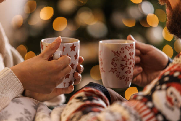 istock Young couple smiling at each other while relaxing and enjoying hot chocolates 1498119139