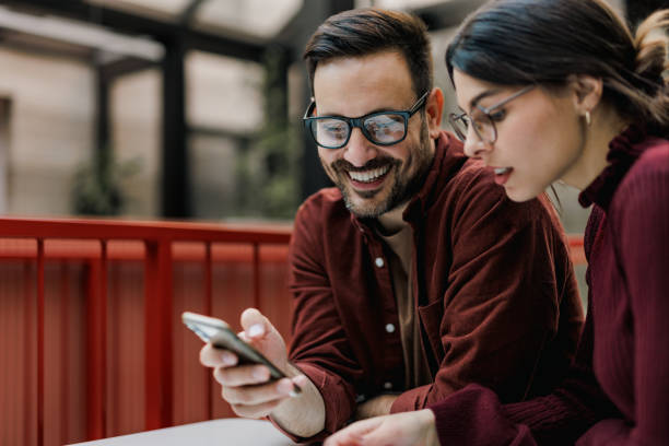 istock Smiling business people using a mobile phone, searching for something online. 1498119708