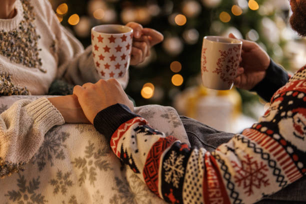 istock Young couple smiling at each other while relaxing and enjoying hot chocolates 1498119941