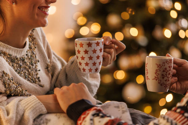 istock Young couple smiling at each other while relaxing and enjoying hot chocolates 1498120039