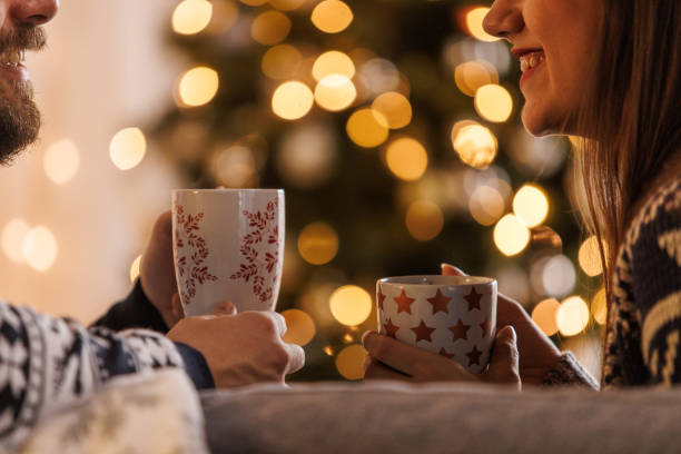 istock Young couple smiling at each other while relaxing and enjoying hot chocolates 1498120318