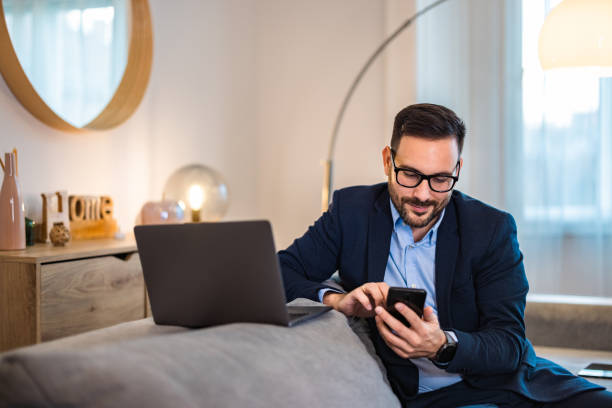 istock Man using a mobile phone while working over the laptop at the home office. 1498120325