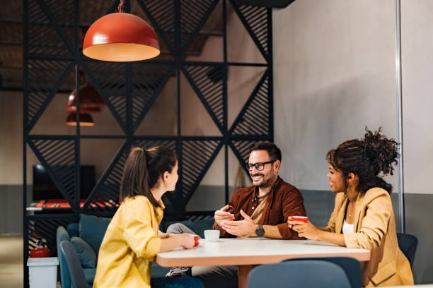 istock Smiling business people talking about new business projects, drinking coffee during the work break. 1498120334