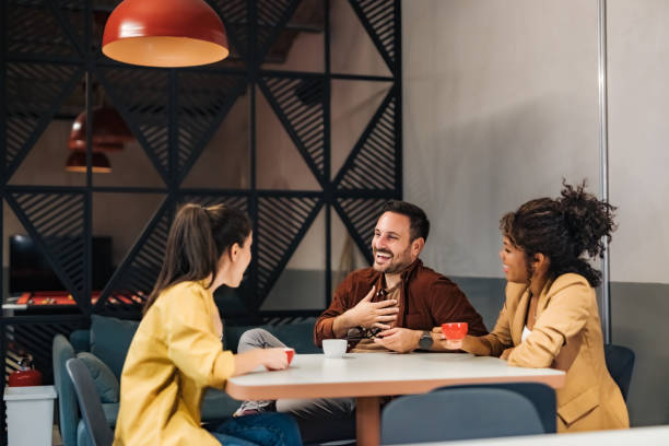 istock Three coworkers laughing on a coffee break, sitting at the workplace. 1498120337