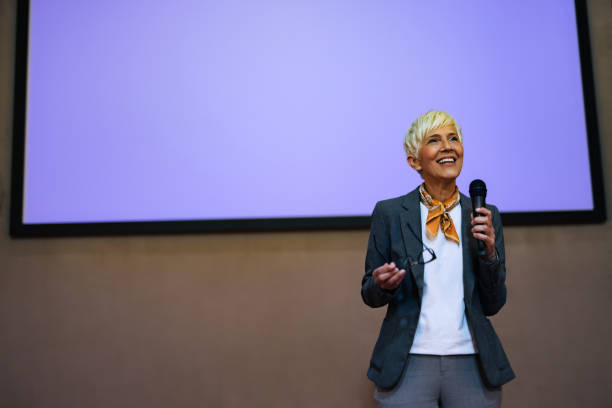 istock Woman giving a speech, standing at a projection screen, presenting a business idea. 1498120339