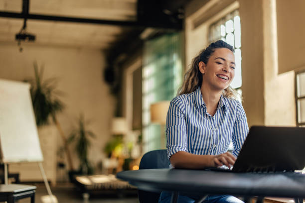 istock A girl using a laptop, lauging, being at the office. 1498120374