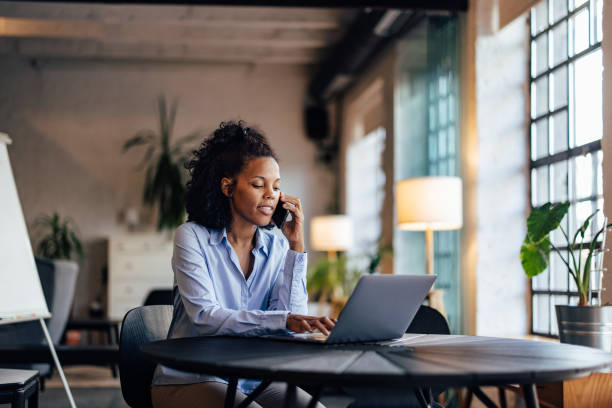 istock African businesswoman making a phone call while working online, talking to one client. 1498120401