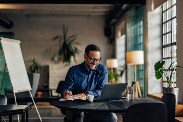 istock Smiling businessman working at his office, writing something in his notebook. 1498120683