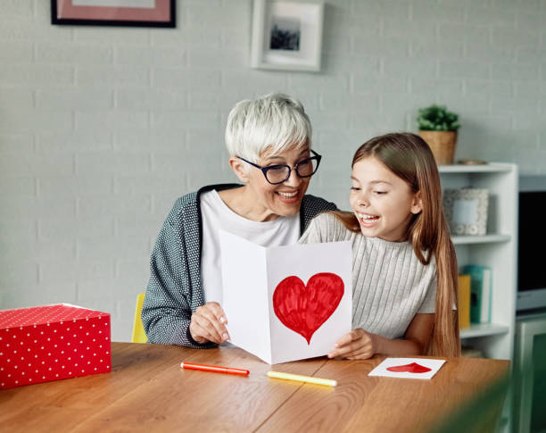 grandmother granddaughter gift present greeting card birthday mother day family greeting card box love celebration holiday granddaughter surprises her grandmother with present on mother's day or birthday at home senior birthday card stock pictures, royalty-free photos & images