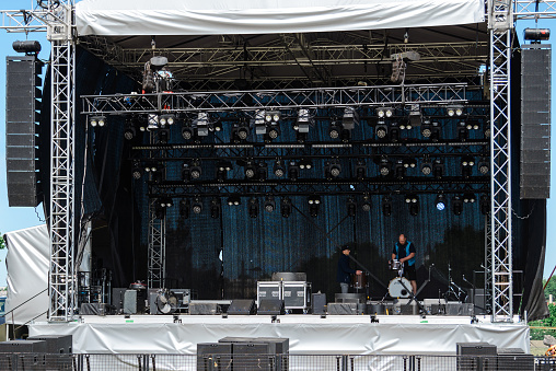 The concert scene,stage is being prepared for festival,celebrations.Lights and stage constructions.Spotlights,laser lights.Giant speakers and sound system.Festival area.Telsiai,Lithuania.06-10-2023.