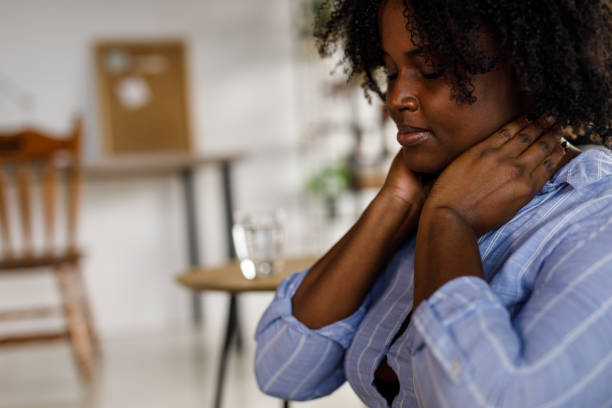 istock Student sitting on the floor, taking a break from studying and stretching her painful neck 1498125040
